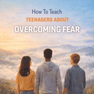 Three teenagers standing on a hill overlooking misty mountains at sunrise with the title “How To Teach Teenagers About Overcoming Fear.”