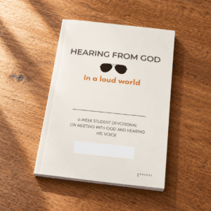 Hearing From God student devotional, a thin matte paperback, on a wooden desk